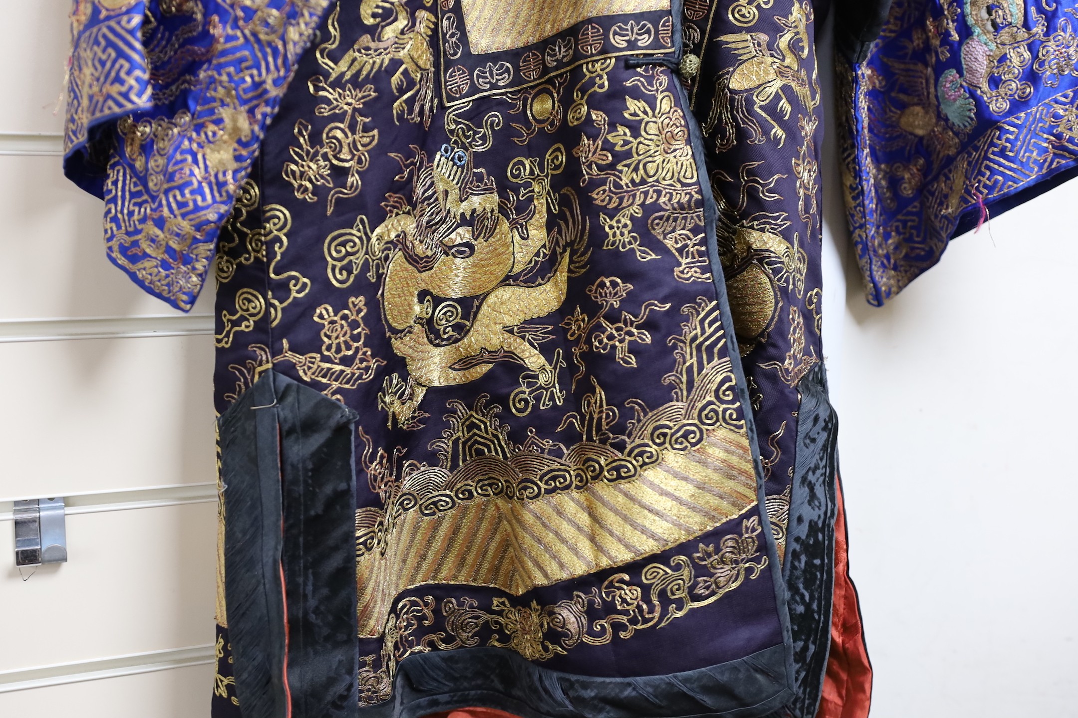 A 20th century Chinese robe, decorated with navy ground and gilt thread all over five claw dragons